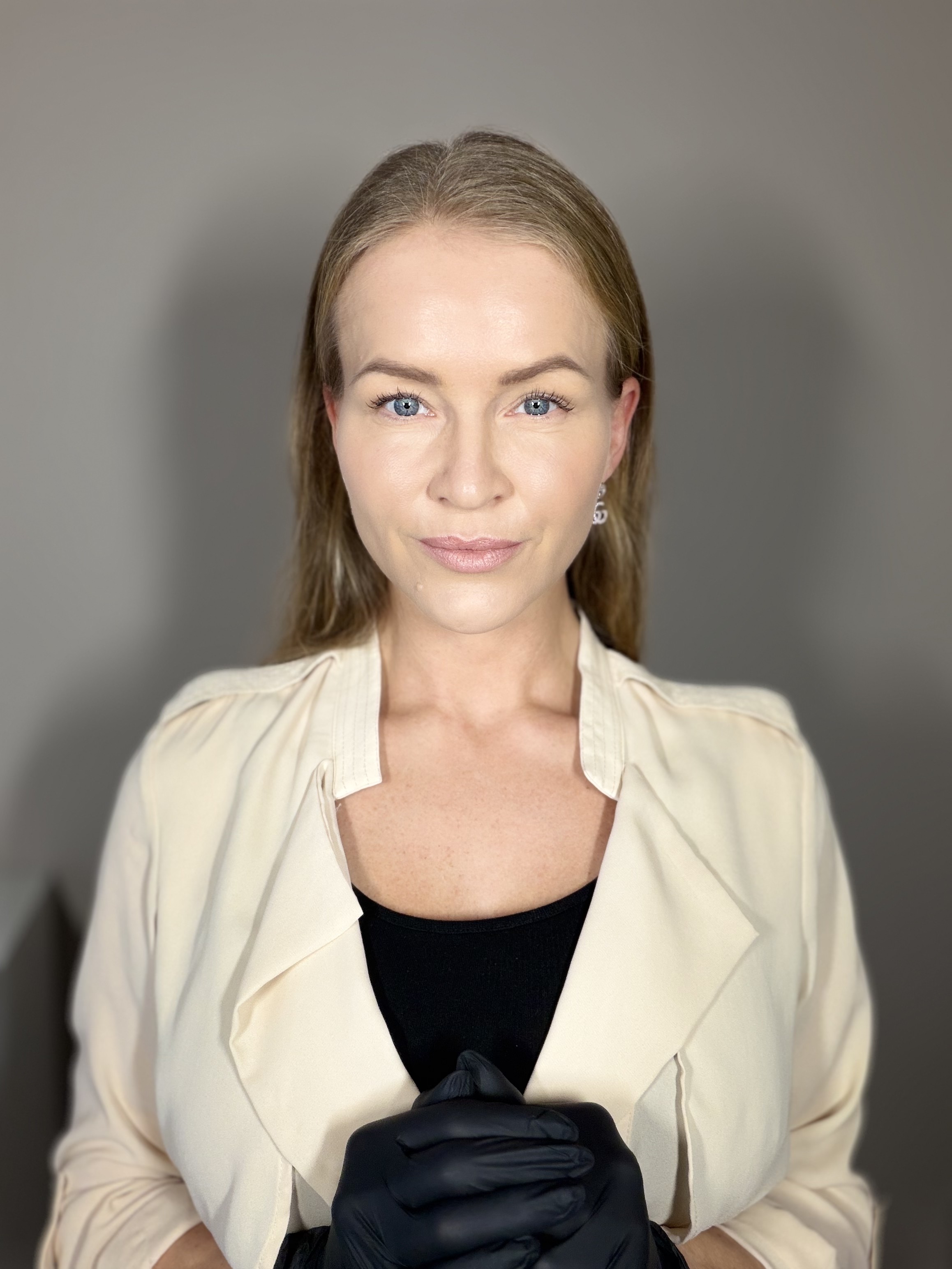 Louise med hænderne samlet foran sig i sorte behandlingshandsker