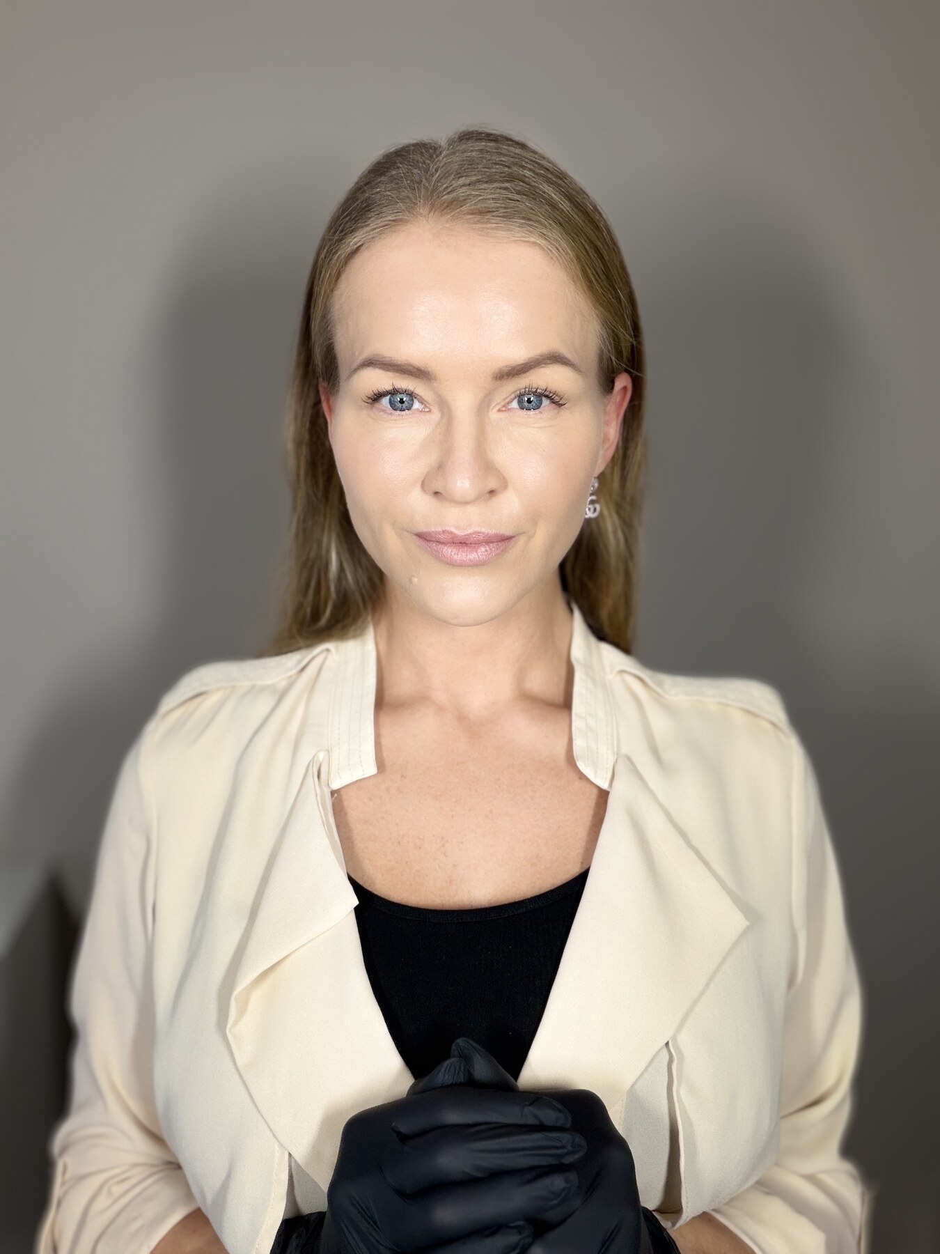Louise med sorte handsker i klinikken