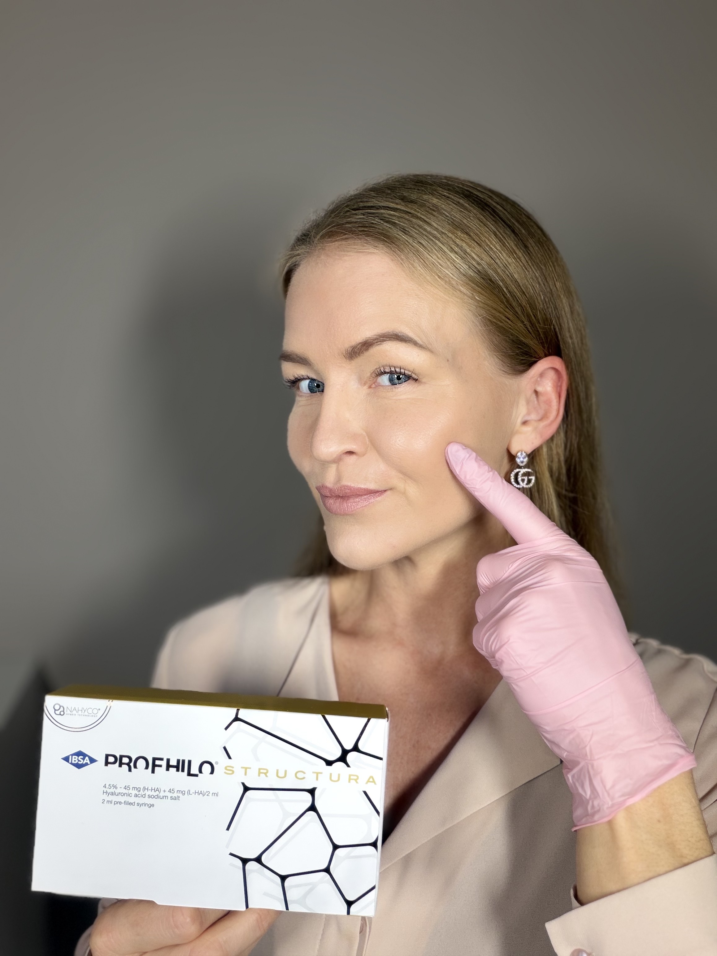 Louise holder en æske Profhilo Structura og peger på kindområdet